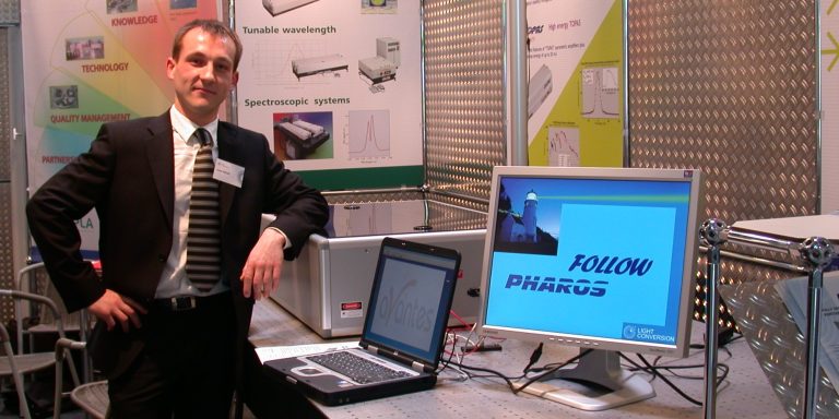 Dr. Jonas Pocius next to the first PHAROS laser at the tradeshow in 2006. 